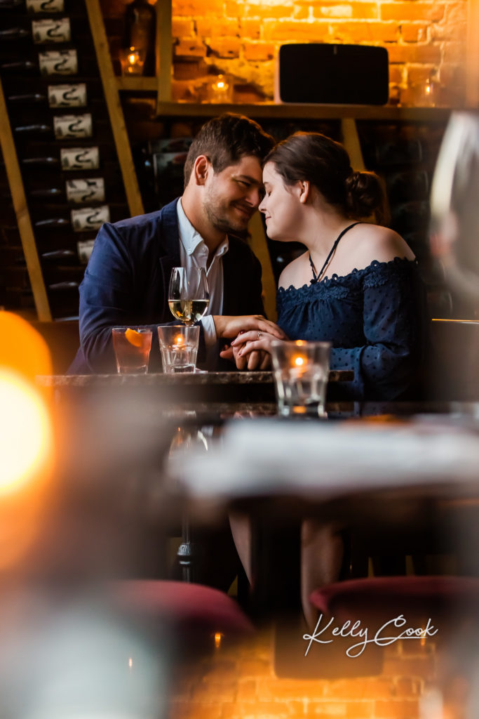 Romantic St. Louis engagement photo in a bar with warm candlelight