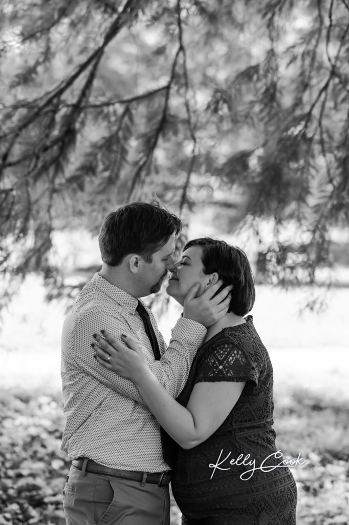 Engaged couple kissing for romantic St. Louis engagement photos in Francis Park