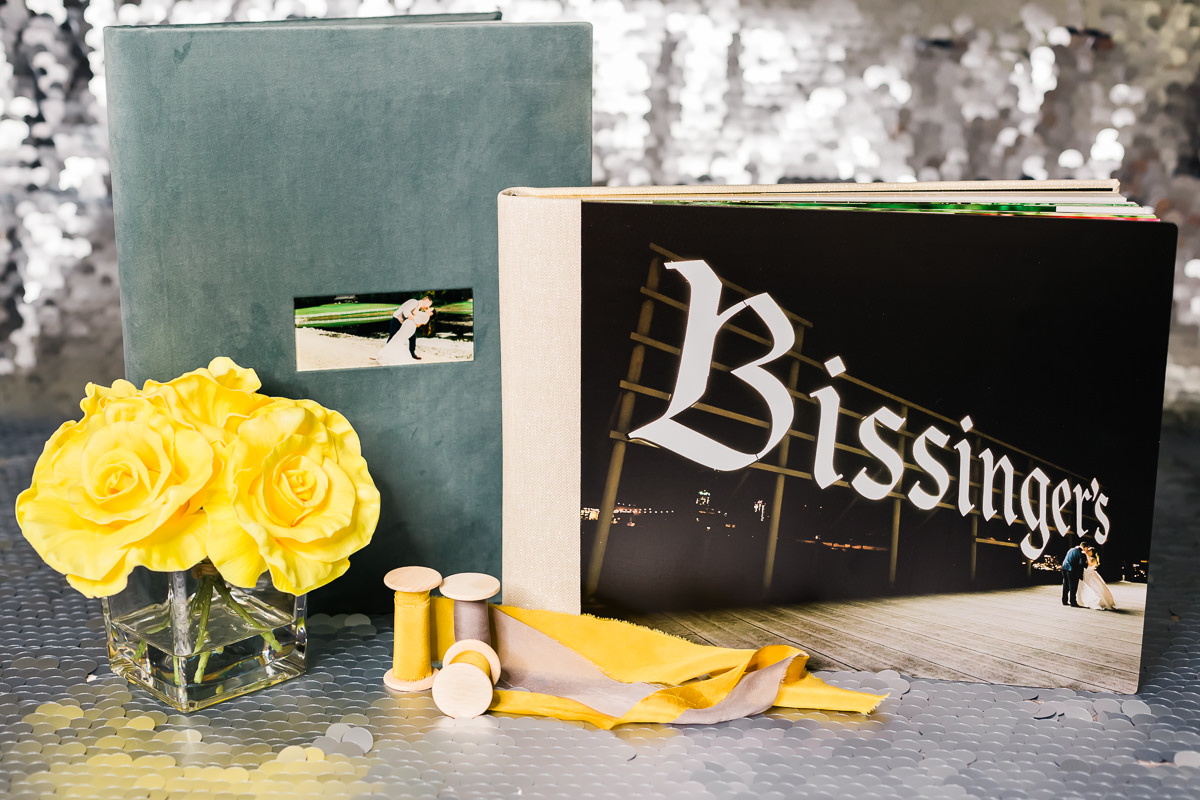 Large photo cover wedding albums styled with flowers and ribbon